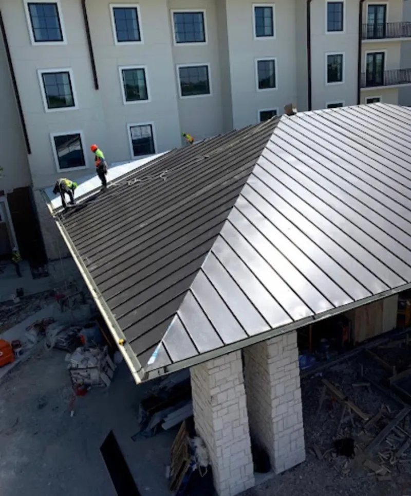 Crew installing standing seam metal roof panels on a commercial project in Bethlehem